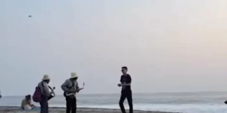 forastero corre y lanza arena a músicos mexicanos en playa de Oaxaca