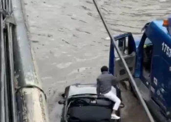 Lluvias: ¡Héroe al balancín! Trailero salva a conductor atrapado en su auto deportivo